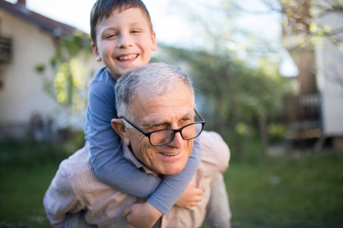 Abuelo disfrutando con su nieto en familia - Adeslas Salud y Bienestar